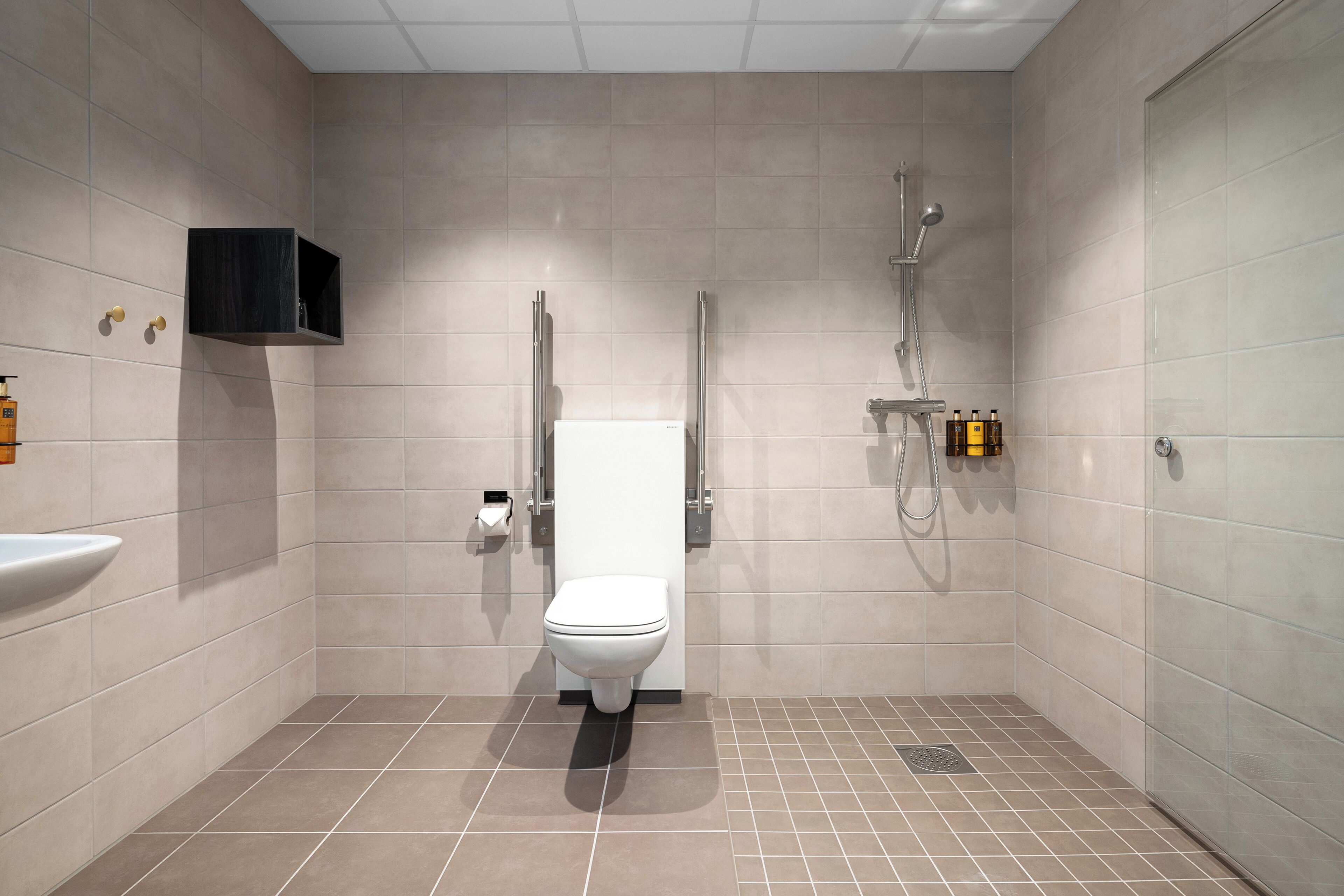 A modern bathroom with a toilet, a sink, and a shower area.