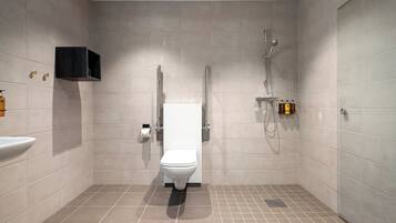 Een moderne badkamer met toilet, wastafel en douche.