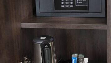 Un mini-frigo con una macchina da caffè Dometic, due tazze bianche, tè Twinings, tè Earl Grey e due vasetti di marmellata.