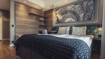 Un dormitorio moderno con una cama grande, un panel de pared de madera, una obra de arte de mármol y un cabecero tapizado en verde.