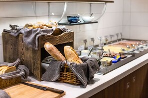 A buffet setup with bread baskets and a variety of food items.