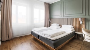 Un dormitorio moderno con un cabecero de madera, una estructura de cama de madera y una silla junto a la ventana.