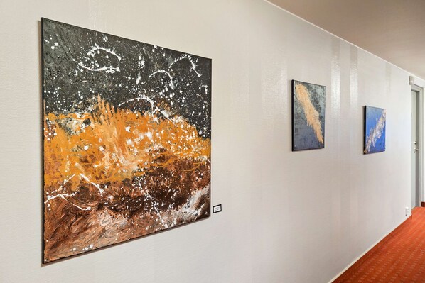 Un pasillo con tres obras de arte en la pared.