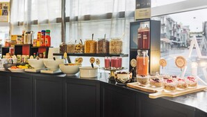 Buffet com diversos alimentos e bebidas, incluindo potes de molhos, potes de frutas e uma seleção de smoothies.