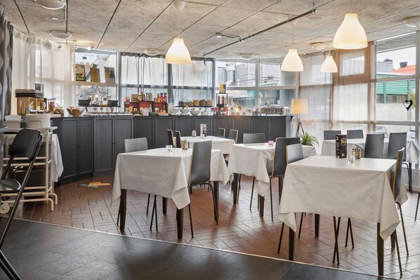 A restaurant with tables and chairs, a bar area, and a view through large windows. - Sure Hotel by Best Western Focus (Ornskoldsvik)
