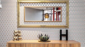 A wooden cabinet with a geometric patterned wall behind it. - Hotel Mälarporten (Vasteras)