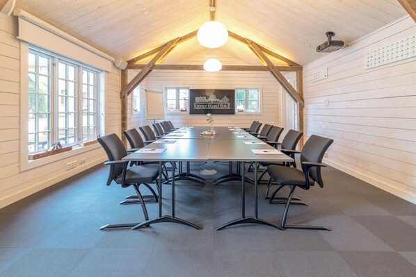 A conference room with a long table, black chairs, and a wooden ceiling. - Kronen Gaard Hotel (Sandnes)