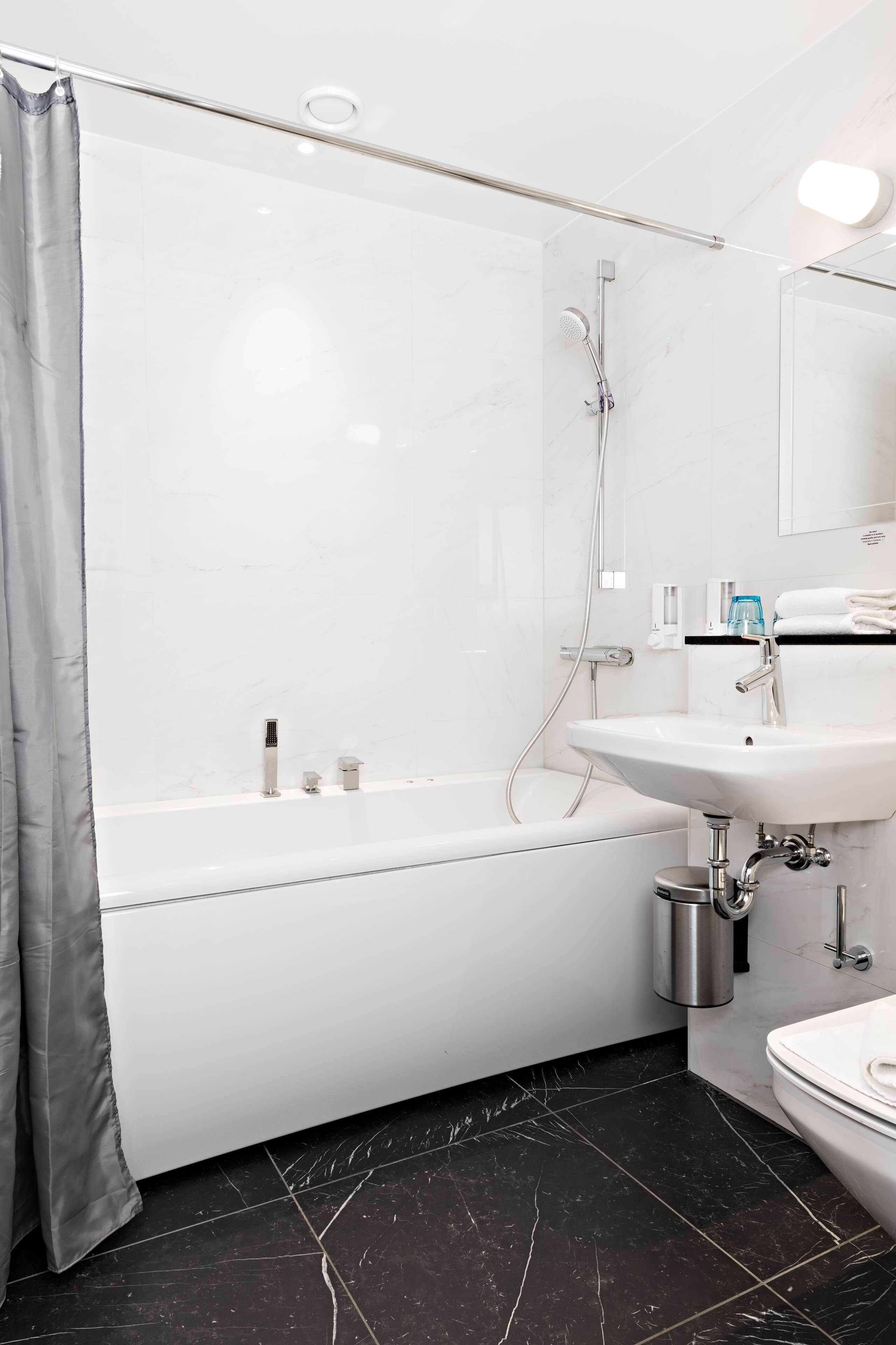 Un baño moderno con bañera, lavamanos e inodoro.