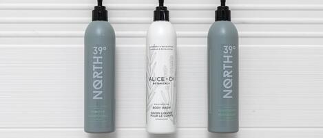 Trois bouteilles de gel douche et de shampoing NORD, sur un fond blanc.