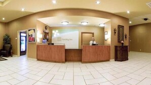 Zona de recepción con un mostrador curvo, un mostrador con ordenador y un mostrador atendido por un recepcionista.