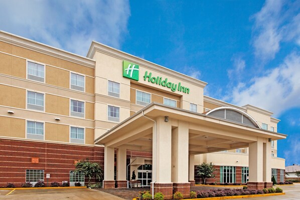 Welcome to the Holiday Inn, featuring a flat roof and symmetrical design with multiple windows on each floor.
