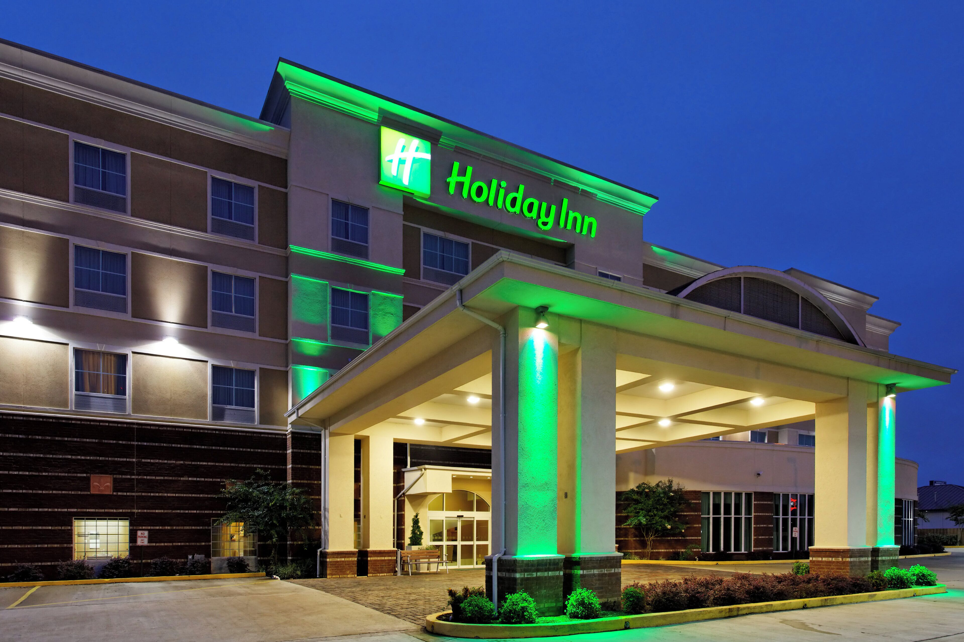 A Holiday Inn hotel with a covered entrance and a brick facade.