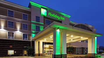 A Holiday Inn hotel with a covered entrance and a brick facade.