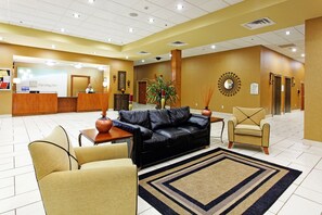 Welcome to our lobby, featuring a reception desk, comfortable seating, and a beautiful decorative wall piece.