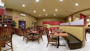 Un restaurante con mesas y sillas de madera, una barra y una decoración grande en la pared.
