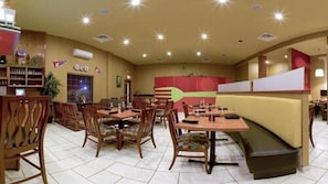 Un restaurant avec des tables et des chaises en bois, un comptoir et une grande décoration murale.
