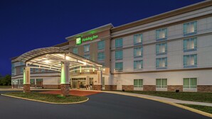 A Holiday Inn hotel with a covered entrance, multiple floors, and a well-lit facade. - Holiday Inn Manassas - Battlefield by IHG (Manassas)