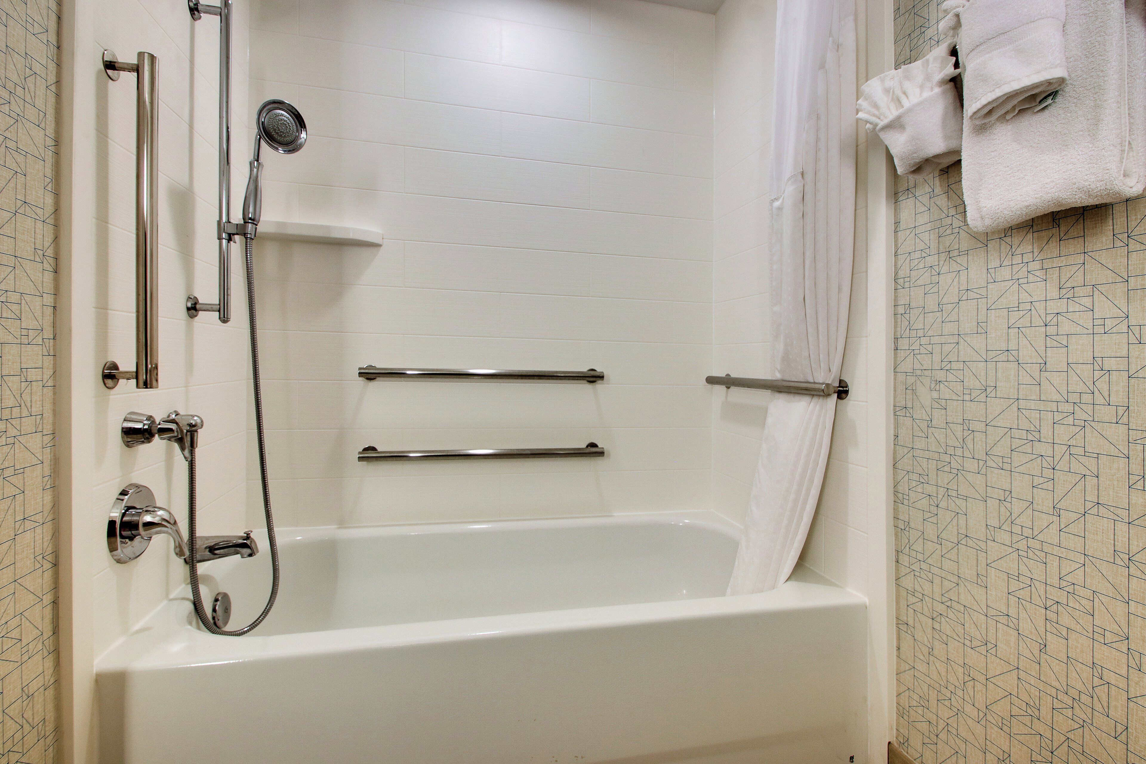 Un baño con bañera, ducha y toallero.
