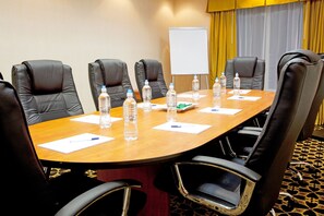 A conference room with a wooden table, black leather chairs, water bottles, and a whiteboard. - Holiday Inn Express & Suites Jacksonville North-Fernandina by IHG (Yulee)