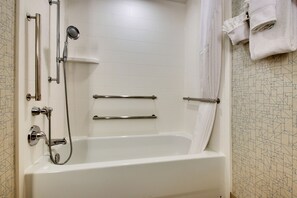 A modern bathroom with a walk-in bathtub, grab bars, and a showerhead. - Holiday Inn Express & Suites Jacksonville North-Fernandina by IHG (Yulee)