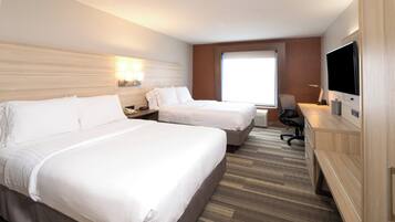 Une chambre d’hôtel avec deux lits, un bureau, une télévision et une fenêtre.