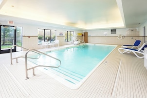Una piscina techada, sillones reclinables de piscina