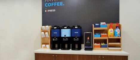 A coffee station with multiple coffee dispensers, a hot water dispenser, and a coffee maker.