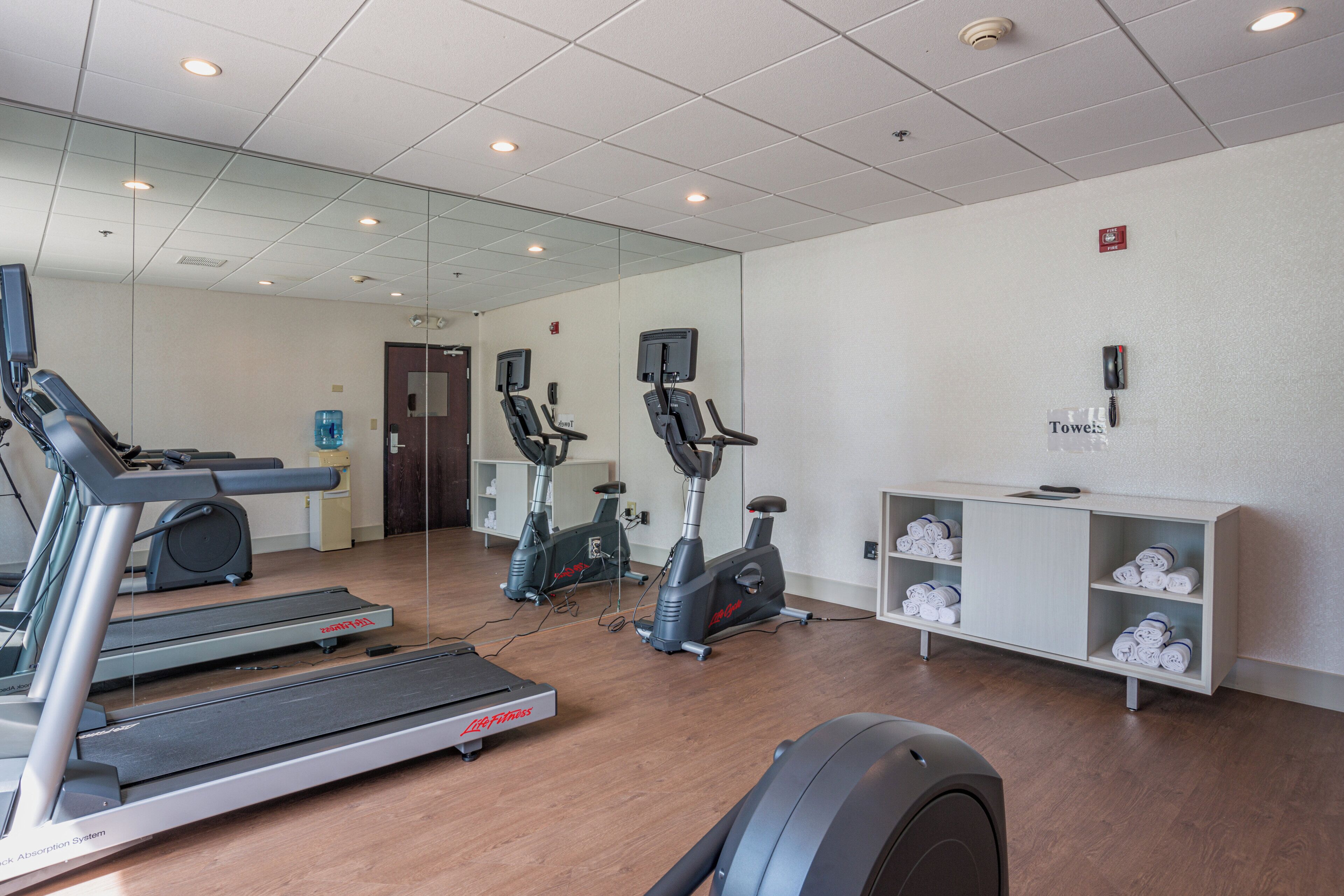 A fitness center with treadmills, stationary bikes, and a water dispenser.