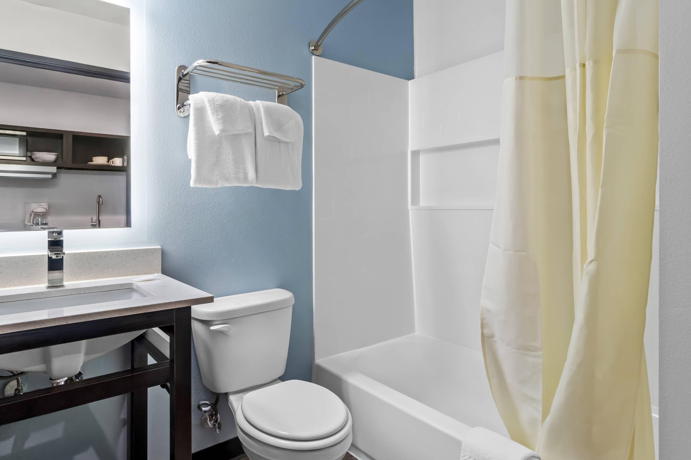 A bathroom with a toilet, sink, and bathtub.