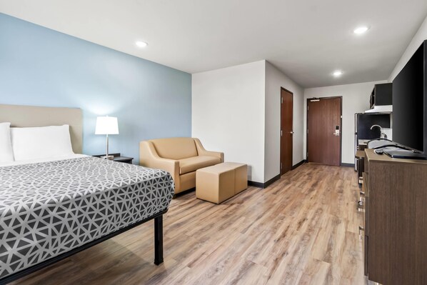 Una camera d'albergo con un letto, una sedia, una scrivania e un armadio.