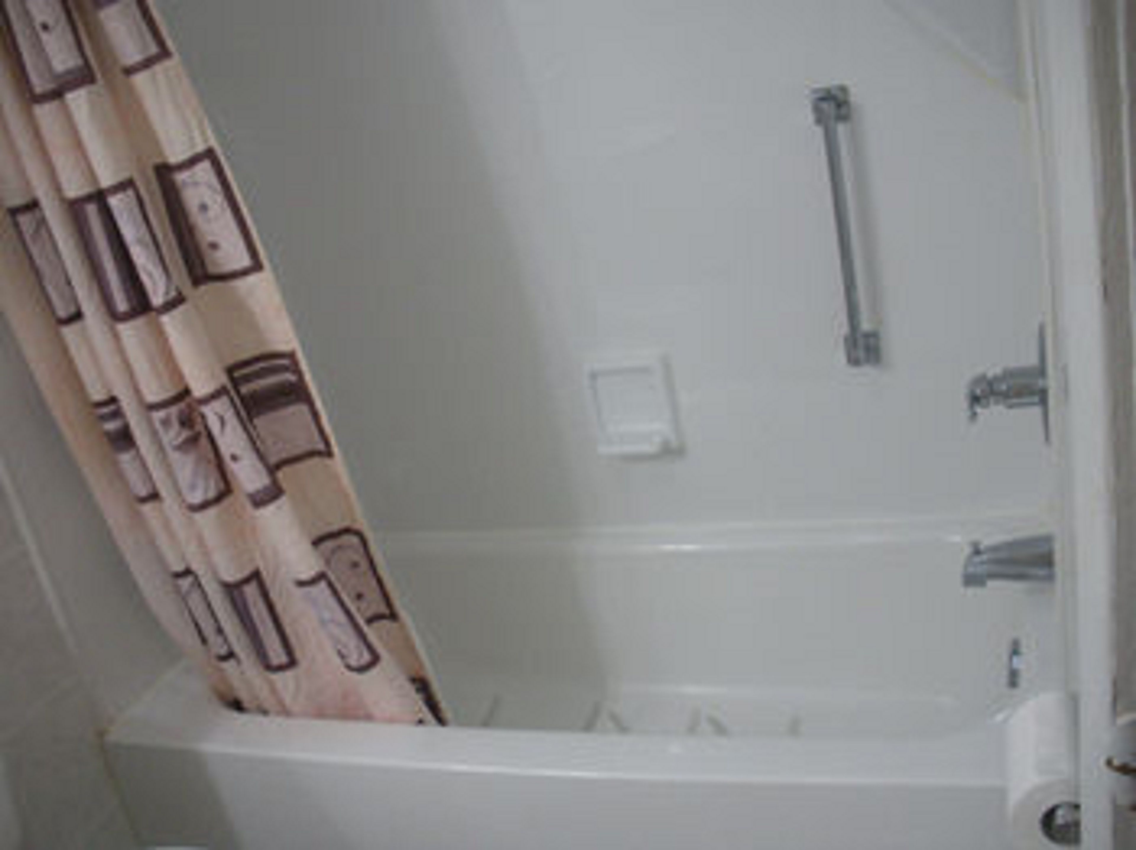 Een badkamer met een bad, een douche en een toilet.