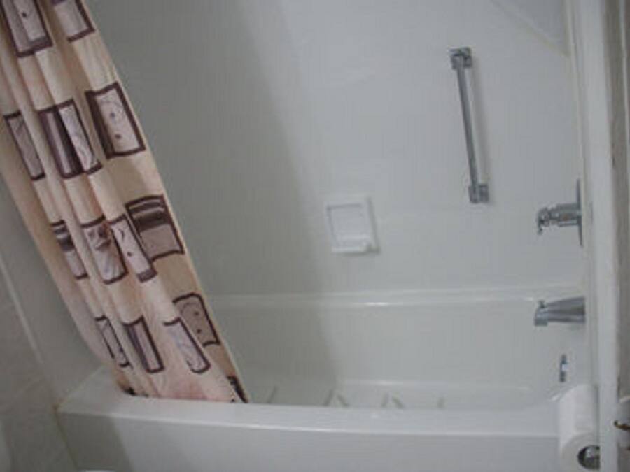 Een badkamer met een bad, een douche en een toilet.