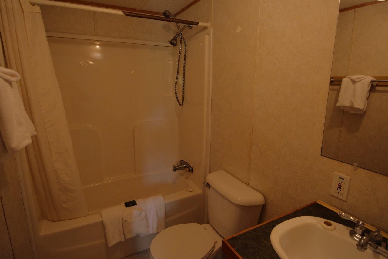 A bathroom with a bathtub, toilet, and sink.
