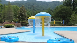 Una piscina con fuentes y aros inflables.