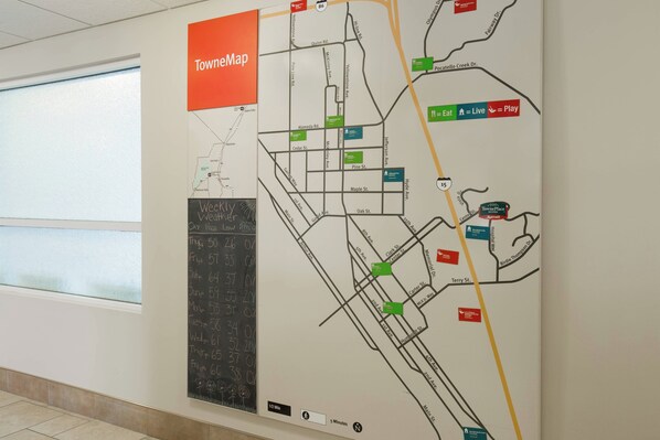 Un mapa mural con un letrero de TownMap, diversos nombres de calles e iconos que señalan servicios como restaurantes y lugares de música en vivo.