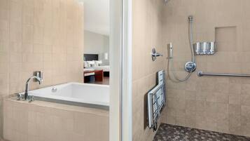 A modern bathroom with a bathtub, shower, and toilet.