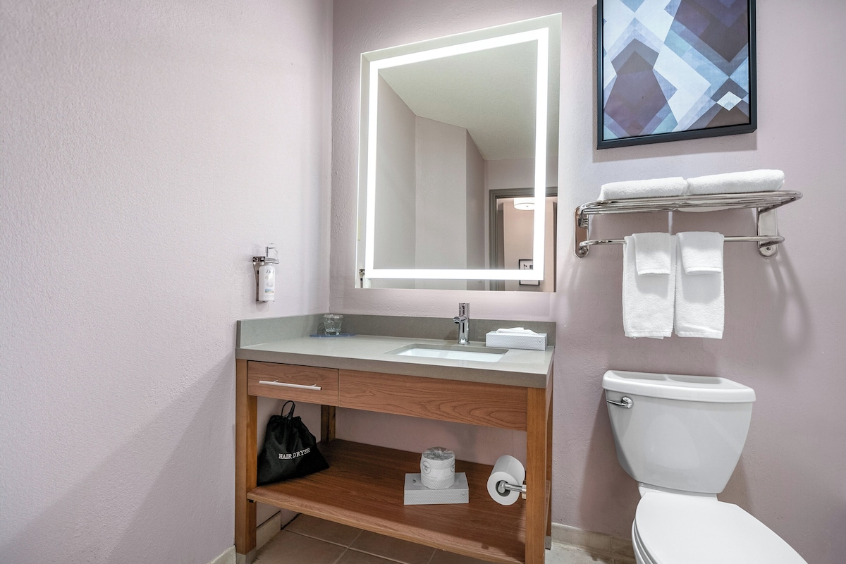 Ein Badezimmer mit Waschtisch, Waschbecken, Spiegel und Toilette.