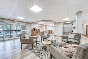 A spacious lobby with a seating area, a kitchenette, and a reception desk.