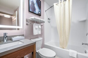 A bathroom with a sink, toilet, and bathtub.