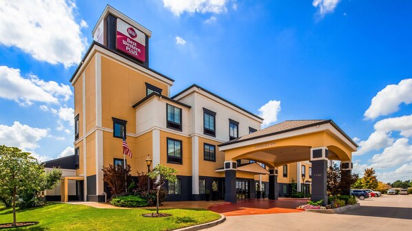 A hotel with a 'Best Western Plus' sign, a covered entrance, and a parking lot.