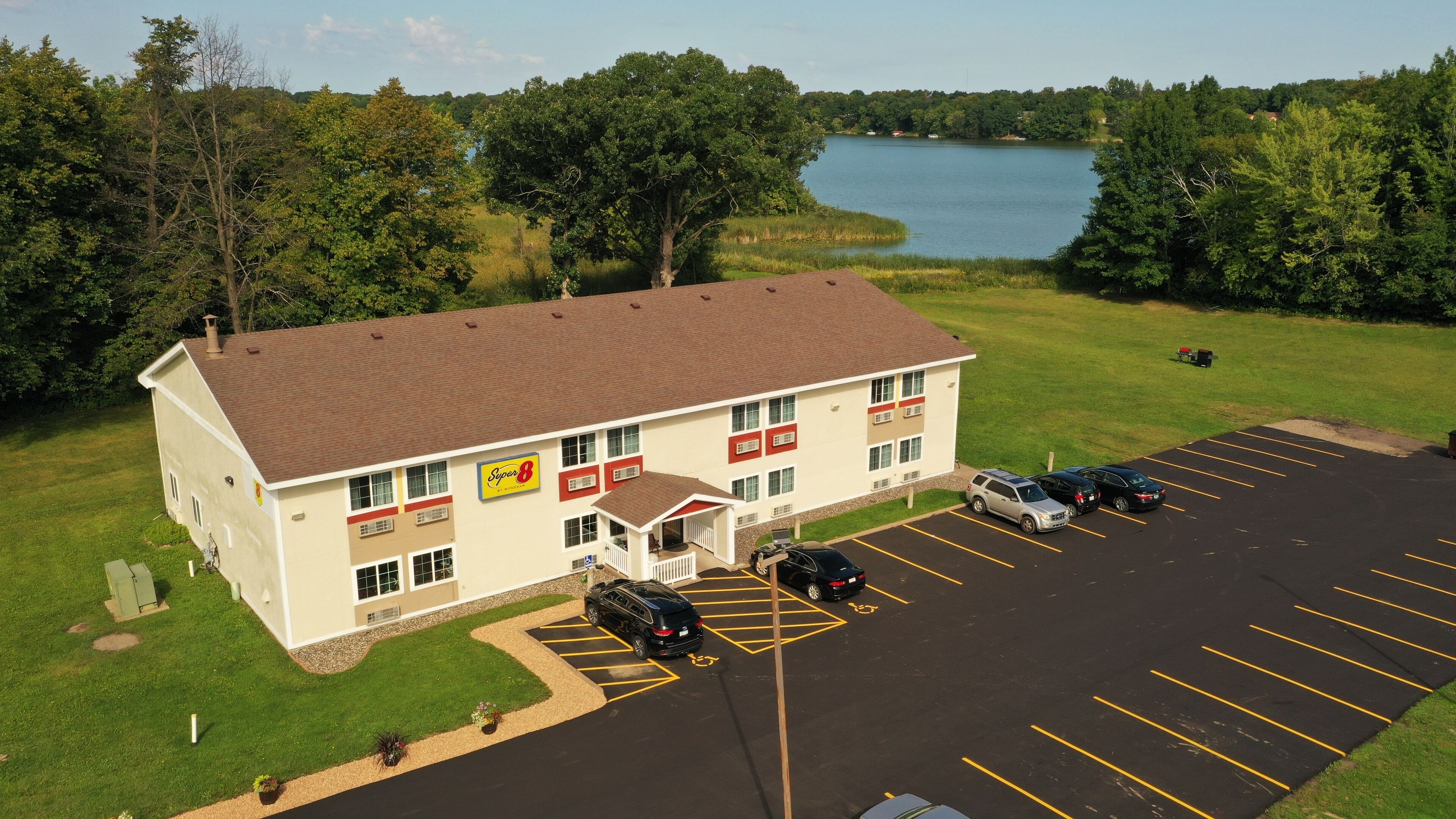 Un hotel con estacionamiento, vista al lago y un letrero que indica que es un Super 8.