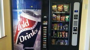 A vending machine with a Coca-Cola advertisement and a selection of snacks. - Super 8 by Wyndham Chisago City (Chisago City)