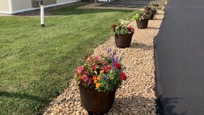A hotel with a parking lot, a building with a sign, and flower planters along the walkway. - Super 8 by Wyndham Chisago City (Chisago City)