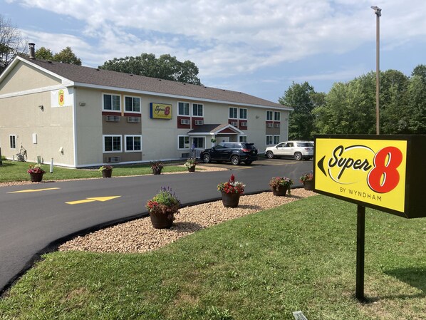 Un motel Super 8 con estacionamiento, un edificio de fachada color beige y un cartel.