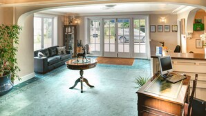 A spacious lobby with a reception desk, a seating area with a sofa, a round table, and a large potted plant. - Lord Haldon Country Hotel, Sure Hotel Collection by Best Western (Exeter)