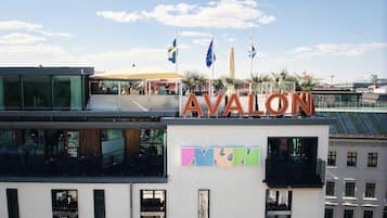 A building with the sign "AVALON" and a rooftop terrace with flags.