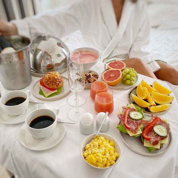 A breakfast setting with a variety of food items and beverages on a table.