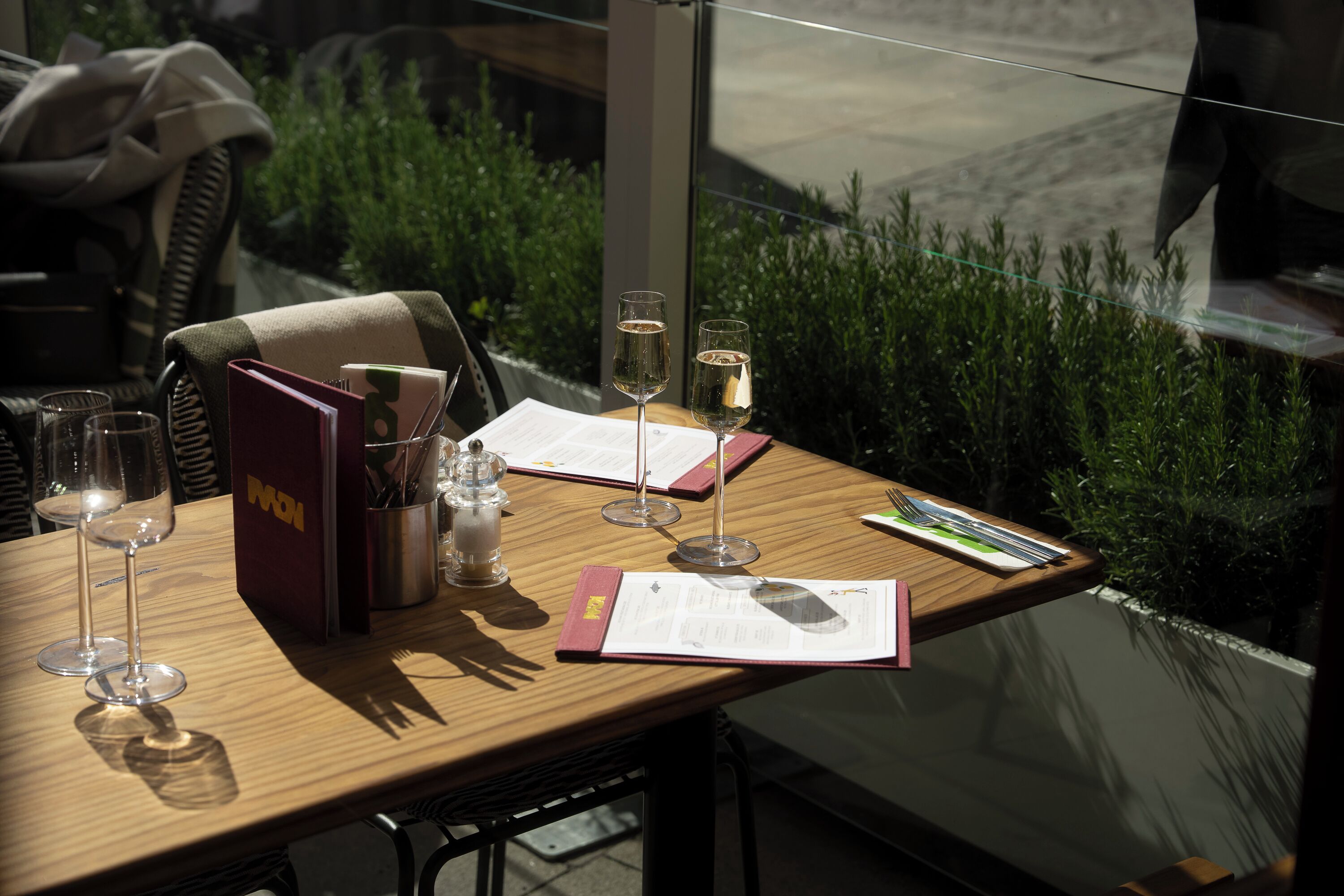 Une table avec deux verres à vin, un menu et un présentoir à menu.