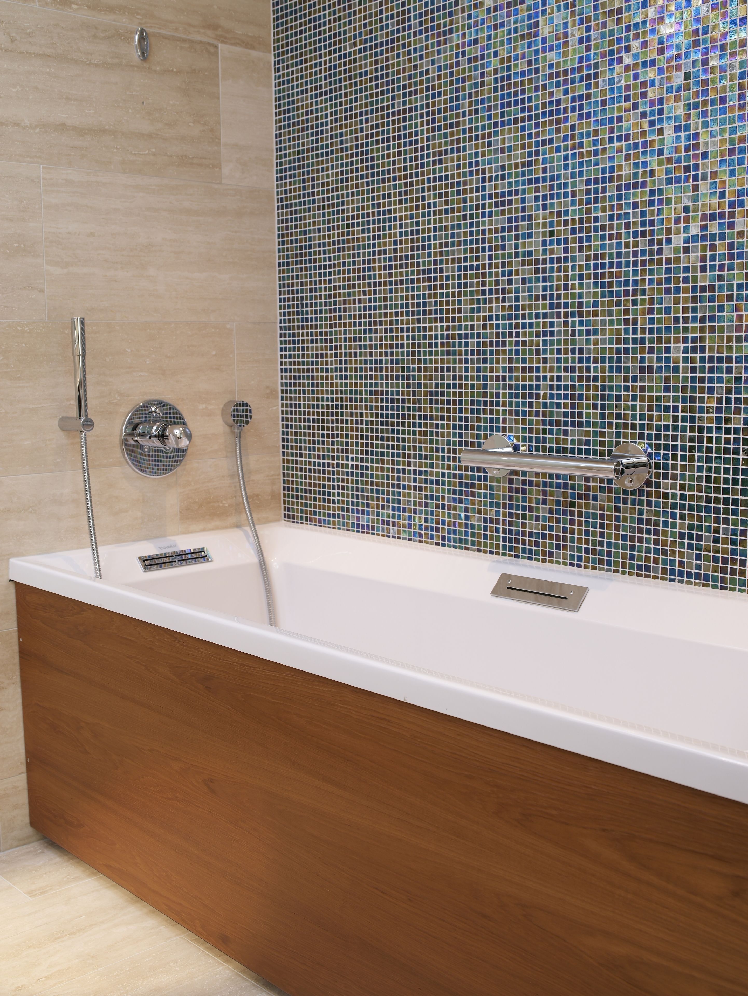 A modern bathroom with a freestanding bathtub, a handheld showerhead, and a wall-mounted faucet.