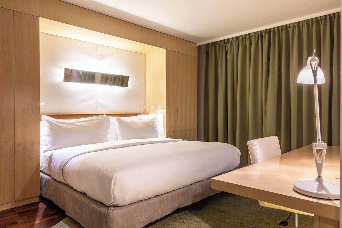 Ein Hotelzimmer mit einem Bett, einem Schreibtisch und einer Lampe.